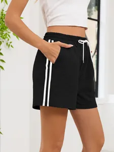 Detail view of women's black athletic shorts with white side stripes and functional pockets