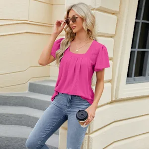 Detail view of the pleated square neck and eyelet embroidery on a pink short sleeve top.
