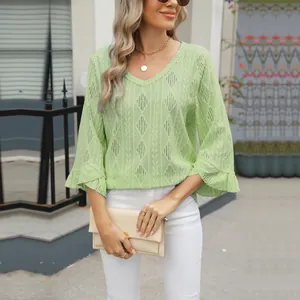 Detailed view of light green V-neck top with diamond hollow jacquard and bell sleeves
