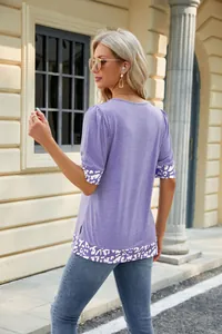 Vista posteriore di una t-shirt viola con maniche a sbuffo, bordo leopardato e spacchi laterali