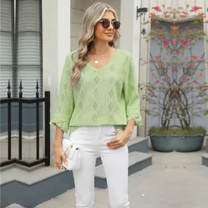 Model wearing a light green V-neck top with diamond hollow-out pattern and ruffle sleeves.
