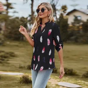 Detail view of women's black V-neck shirt featuring elegant colorful feather prints