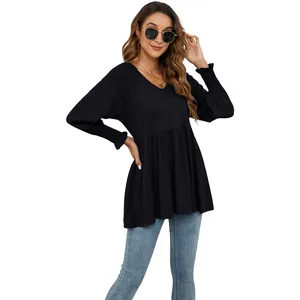 Tunica nera con scollo a V, maniche a sbuffo arricciate e vita a peplo con jeans.