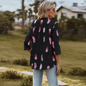 Back view of a casual black loose shirt featuring vibrant red and white feather prints.