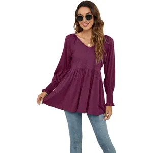 Dettaglio di un top peplum viola con scollo a V e maniche a sbuffo su sfondo bianco