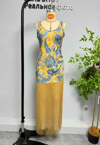 Close-up detail of the paisley floral print and long gold fringe hem on the sleeveless dress.
