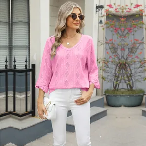 Detailed view of women's pink V-neck top featuring diamond pointelle knit and flare sleeves