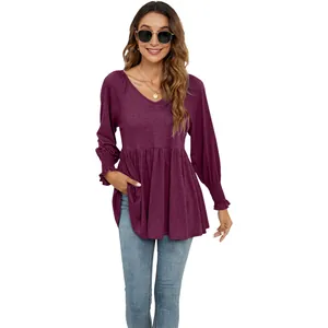Dettaglio top viola con scollo a V, maniche a sbuffo e vita a peplo elegante.