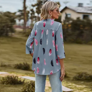 Back view of a casual loose blue blouse with vibrant feather print and 3/4 sleeves.