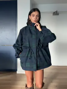 Detailed view of model wearing a dark blue plaid drawstring jacket with a stand collar