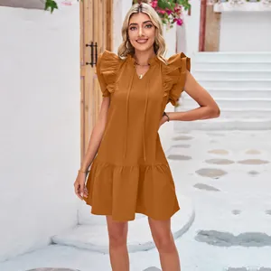 Detailed view of terracotta ruffle sleeve dress with pleated hem and ruffled collar