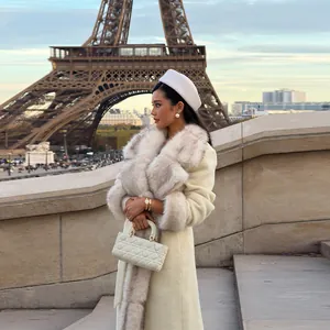 Elegant long wool coat featuring a luxury faux fur collar in a Parisian street setting.