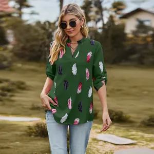 Close-up detail of women's dark green V-neck blouse featuring vibrant feather print patterns