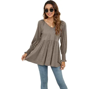 Dettaglio di un top babydoll grigio-marrone con scollo a V e polsini elastici smock