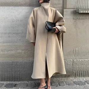 Detail view of a stylish oversized long coat with stand-up collar and batwing sleeves