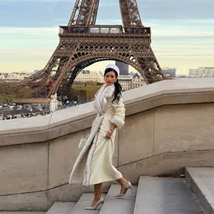 Elegant long cream-colored woolen winter coat with plush faux fur collar and waist belt