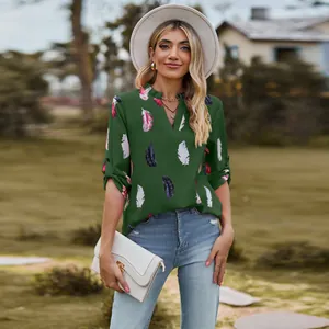 Women's green V-neck blouse with colorful feather prints and casual roll-tab sleeves.