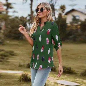 Detailed view of women's green V-neck blouse featuring artistic feather print and 3/4 sleeves