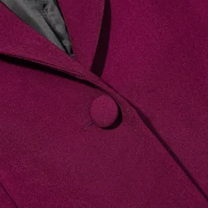 Detailaufnahme eines burgunderfarbenen Blazers mit stoffbezogenem Knopf und Revers