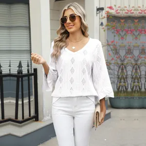 Detailed look at white V-neck shirt with hollow diamond jacquard and bell sleeves.
