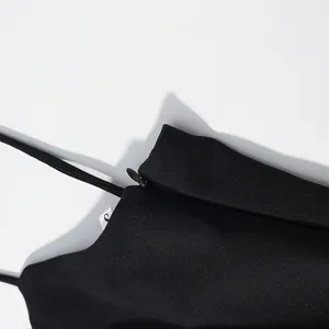 Close-up of the hidden side zipper and thin strap on a black camisole dress