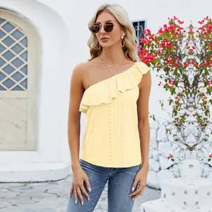 Model wearing yellow one-shoulder ruffle top with delicate eyelet embroidery fabric