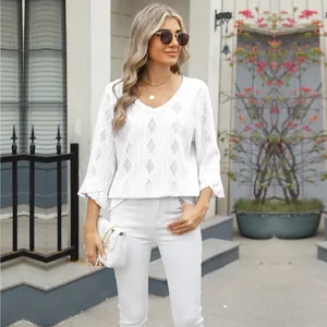 Fashionable detail of women's white V-neck hollow jacquard top with elegant bell sleeves