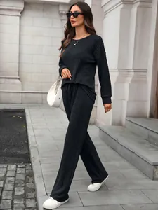Close-up of black ribbed knit loungewear set featuring a long sleeve top and wide-leg pants.