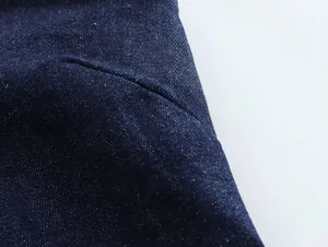 Nahaufnahme von hochwertigem dunkelblauem Denim-Stoff und feinen Nahtdetails an einem Damenkleid