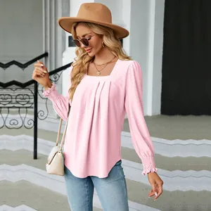Detail shot of a women's pink jacquard blouse with square neck and pleated design.