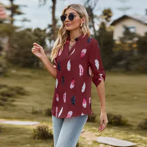 Outdoor lifestyle shot of a wine red feather print V-neck shirt for women