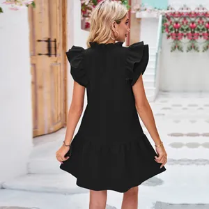 Rear view of a chic black ruffle sleeve pleated mini dress featuring a layered hemline.