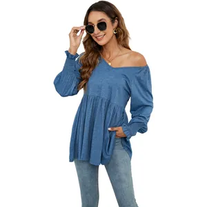 Primo piano del top blu a maniche lunghe con scollo a V e bordo a peplo