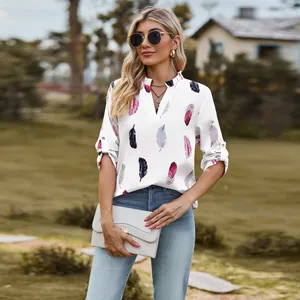Detail shot of white V-neck blouse with colorful feather print and adjustable 3/4 sleeves