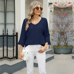 Woman in navy blue V-neck diamond jacquard top with hollow details and bell sleeves