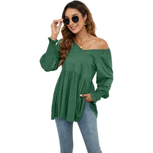 Dettaglio della blusa verde a maniche lunghe con scollo a V, maniche a sbuffo e polsini smocked