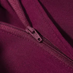 Detailaufnahme eines farblich abgestimmten Reißverschlusses an einem weinroten Blazer