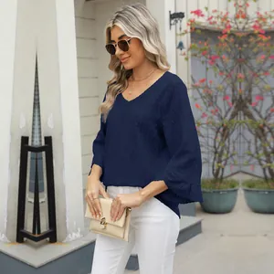 Detailed view of a woman wearing a navy V-neck jacquard top with hollow bell sleeves