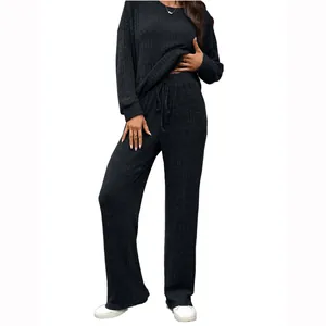 Two-piece black ribbed knit loungewear set with long-sleeve top and drawstring pants.