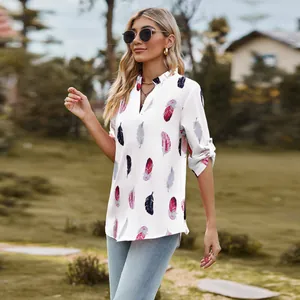 Detail view of a white V-neck shirt featuring elegant colorful feather prints.
