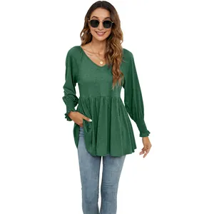 Dettaglio della maglia verde da donna con scollo a V, maniche a sbuffo e orlo a baschina.