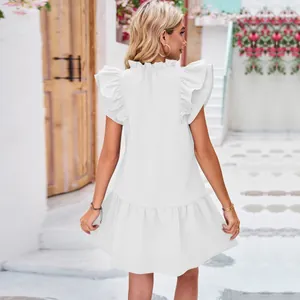 Back view of a white mini dress with ruffle sleeves and pleated hem detail