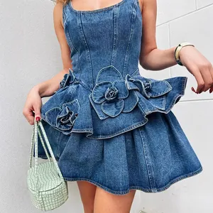 Detailansicht eines blauen Jeanskleides mit 3D-Blumenapplikationen und verspieltem Faltenrock