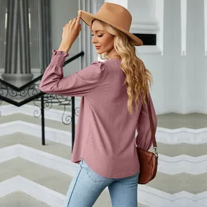 Back view of a stylish mauve jacquard long-sleeve blouse with textured smocked cuffs.