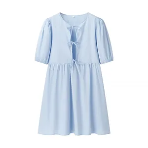 Détail de robe bleu clair à manches courtes avec trois nœuds papillon à l'avant