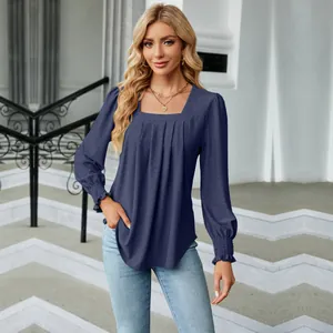 Close-up of women's navy blue blouse with square neckline and jacquard pleated texture.