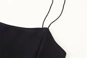Detail view of thin spaghetti straps and sheer black fabric on a stylish dress