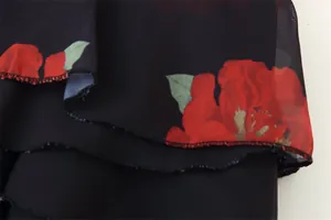 Close-up detail of floral print chiffon fabric with layered ruffles and red flowers.