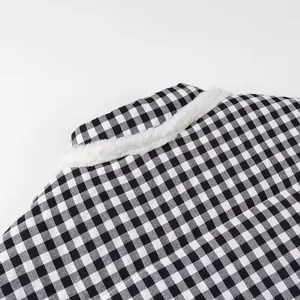 Detail view of the white faux fur collar on a black and white gingham padded jacket