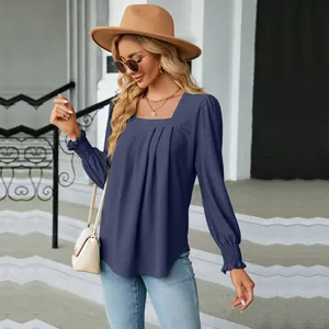 Outdoor street view of a women's square neck navy blouse with pleated jacquard detail
